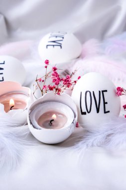 Paskalya bayramı. Kendiniz yapın. Paskalya Yumurtası Kompozisyonu. Paskalya mesajı, kalemle çizilmiş kelimeler. Masadaki kabukların yüksek açılı görüntüsü. Sevgi. Yumurta kabuğunda mum. Mum ışığı Pastel renkleri.