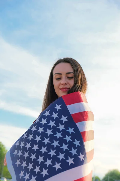 Молода жінка тисячолітньої брюнетки, яка тримає Національний прапор США. Американський прапор. Туристичний мандрівник або патріотизм. Іммігрант у вільній країні. 4 липня - День незалежності. Кавказ — стокове фото