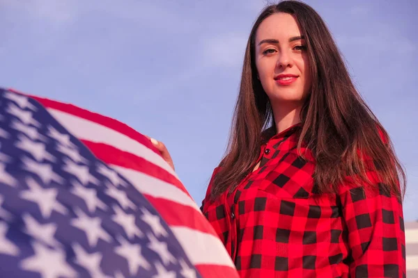 Joven morena milenaria sosteniendo La Bandera Nacional de USA. Bandera Americana. Viajero turístico o patriotismo. Inmigrante en el país libre. 4 de julio Día de la Independencia. Caucásica —  Fotos de Stock