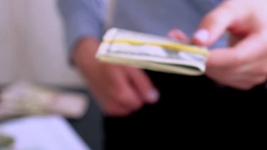 İş kadını, Amerikan dolarlarını sergiliyor. Yakın plan. Gelir ve İş Konsepti. Satış, rüşvet, yolsuzluk konsepti. El çabukluğu. Milenyum Samimi, otantik kadın elleri