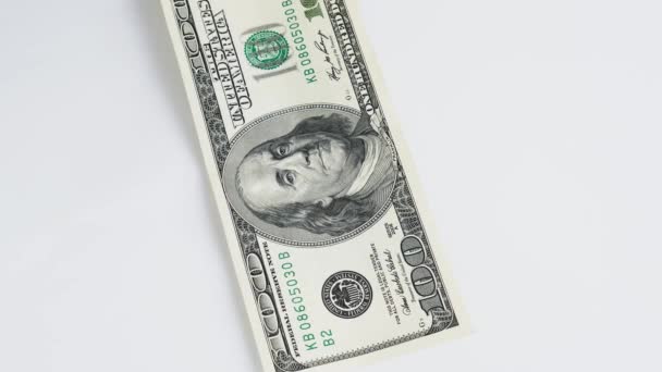 Billetes de dólar americano cayendo uno tras otro en la mesa blanca de cerca. Estadounidenses disparando macro dólares. Cien dólares.. — Vídeo de stock