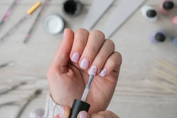 Modern female nude design manicure. Nail care, Self care. Do manicure by yourself while staying at home. Female hands and manicure tools. Spa salon. Professional Hardware Manicure. Procedure for the preparation of nails. Cuticle Pusher Remover. Nail