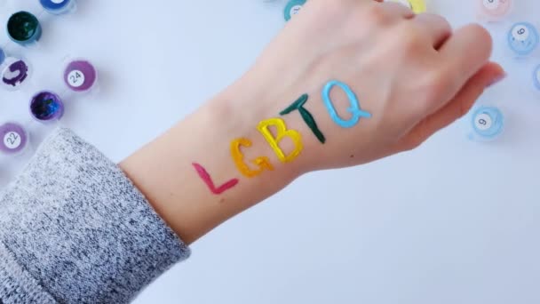 Regenboog LGBTQ vlag geschilderd bij de hand. Steun voor de Igbt gemeenschap. Eer van trotse maand. Mensen verbinden, handen aanraken. — Stockvideo