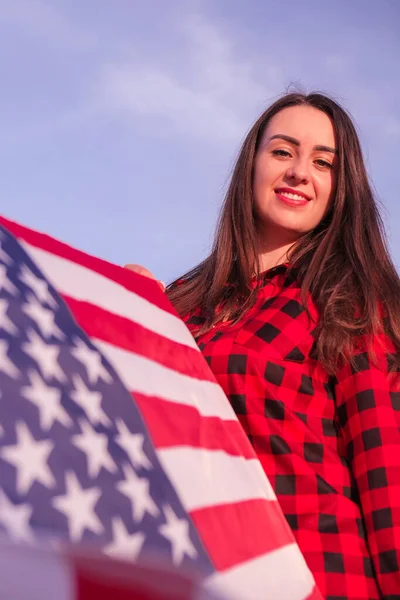 Joven morena milenaria sosteniendo La Bandera Nacional de USA. Bandera Americana. Viajero turístico o patriotismo. Inmigrante en el país libre. 4 de julio Día de la Independencia. Caucásica —  Fotos de Stock