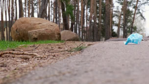 4k Young Volunteer coleta de lixo usado máscara protetora no parque, floresta. Recolha lixo do relvado. Equipamento de proteção individual usado EPI. Poluição plástica após a pandemia. Cuidados com — Vídeo de Stock