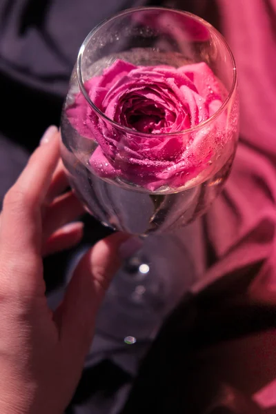 Weinglas Gefüllt Mit Rosa Blütenblatt Tisch Mit Schwarzem Seidenstoff Minimal — Stockfoto