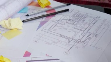 4k Mimari Tasarımcı iç mimari, yaratıcı el işçiliği, masa mimarisi planında blok tahtası oyunu, renk paleti. Ofisteki işyerinin planlarını çizen kadın mimar.