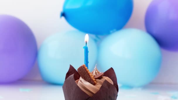 Gâteau au chocolat sucré et savoureux avec combustion de bougies sur fond de fête bleu. Flamme, soufflage Joyeux anniversaire concept de fête. Délicieux gâteau d'anniversaire — Video