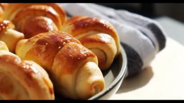 Mutfak havlusunda dönen tatlı gri bir tabakta ev yapımı lezzetli kruvasanlar. Lezzetli ev yapımı kruvasan keki