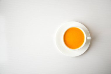 Kabak püresi, baharatlı latte. Beyaz arka planda beyaz bardakta alkollü kokteyl. Sonbahar mevsimlik sıcak içecekler. Şükran Günü. Üst görünüm