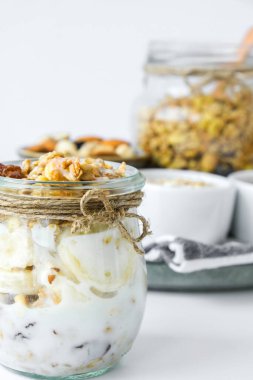 Sağlıklı kahvaltı. Yunan yoğurtlu yulaf ezmesi ve arka planda muzlu müsli. Vejetaryen, vejetaryen ve kilo verme diyeti. Detoks menüsü. Sağlıklı beslenme.