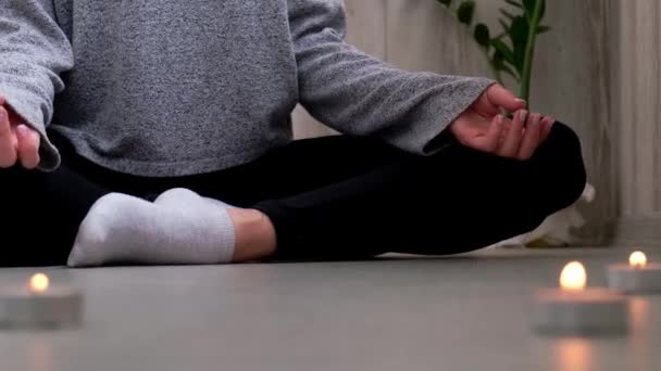 Närbild. Kvinna som motionerar yoga hemma. Mindfulness meditation. Koppla av andas lätt utgör gym hälsosam livsstil koncept. Brännande ljus tänds. Lotus asana. Atmosfär för avkoppling och zen. — Stockvideo