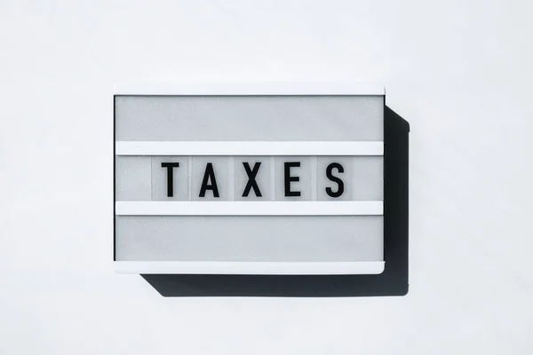 Lightbox Board Sobre Fundo Branco Com Palavras Taxes Letras Pretas — Fotografia de Stock