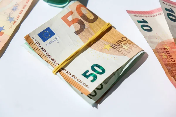 Close up of Euro money roll. Euro banknote set cash money - EU currency. Rolled with rubber euro notes. Business budget of wealth and prosperity finance. Banknotes stacked on each other in different positions.