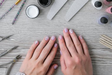 Modern çıplak kadın manikürü. Tırnak bakımı, kişisel bakım. Evde kalırken kendi kendine manikür yap. Kadın eli ve manikür aletleri. Spa salonu. Profesyonel Donanım Manikürü. Çivi hazırlama prosedürü. Tırnak içi temizleyicisi. Çivi 