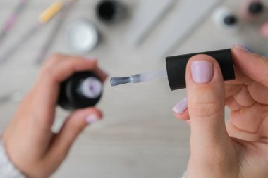 Modern çıplak kadın manikürü. Tırnak bakımı, kişisel bakım. Evde kalırken kendi kendine manikür yap. Kadın eli ve manikür aletleri. Spa salonu. Profesyonel Donanım Manikürü. Çivi hazırlama prosedürü. Tırnak içi temizleyicisi. Çivi 