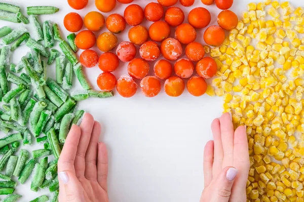 Frozen vegetables food background of yellow corn, green beans, red tomatoes. Harvest Food preservation for winter. Copy space