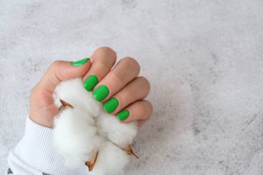 Manikürlü, yeşil tırnaklı kadın elleri. Modern moda tasarım manikürü. Jel tırnaklar. Cilt bakımı. Güzellik tedavisi. Tırnak bakımı. Sağlıklılık. Moda renkleri.