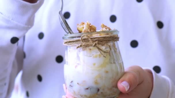 Mãos femininas, mulher a comer pequeno-almoço saudável. Aveia em câmara lenta Granola com iogurte grego e nozes banana muesli em frasco. Vegan, vegetariano e conceito de dieta de perda de peso. Menu Detox. — Vídeo de Stock