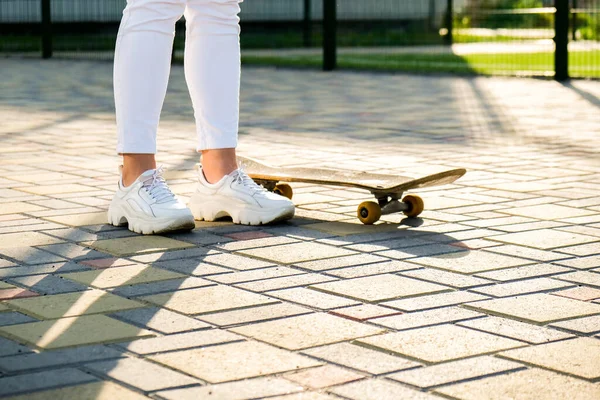 Close up Dívka skateboardista nohy skateboarding při západu slunce. sluneční podsvícení a svoboda vzbouřit nezávislý koncept. Den strávený aktivním koníčkem tabule. — Stock fotografie