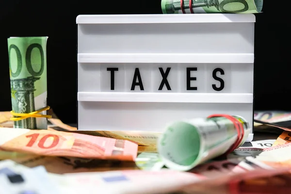 Tableau Lightbox Avec Mot Taxes Lettres Noires Autour Des Billets — Photo