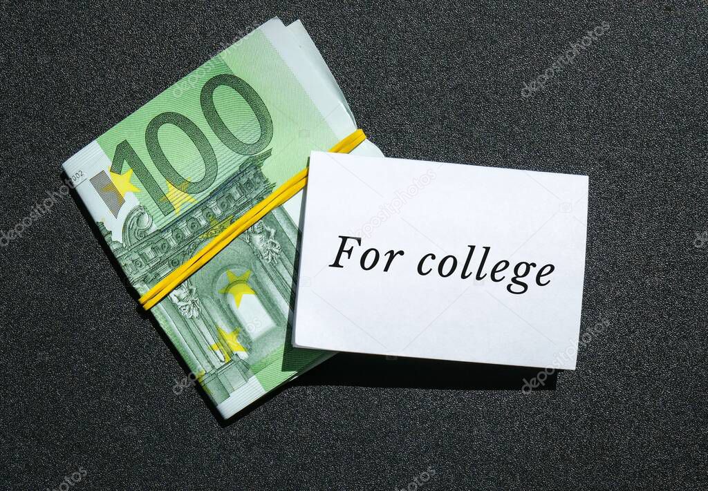 Euros cash money in rubber band with text written note FOR COLLEGE. Concept of financial planning to save money for purpose of education. Save money today for future