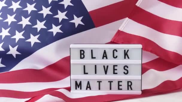 4k挥动美国国旗背景。带有文字的灯箱BLACK LIVES MATTER美利坚合众国国旗。7月4日独立日美国爱国主义国定假日.Usa自豪. — 图库视频影像