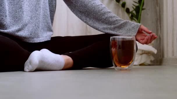 Ung tusenårig blond kvinna dricker te och gör yoga motion stretching fitness på balkong hem. Mindfulness meditation. Begreppet hälsosam kost, miljövänlighet och noll — Stockvideo