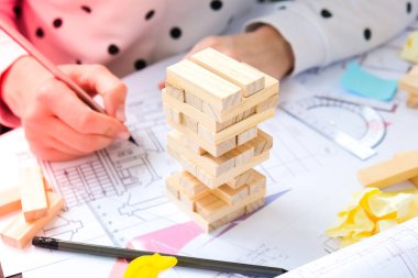 Mimar tasarımcı iç mimar yaratıcı işçi el evin masa mimarisi planı üzerine bir blok tahtası oyunu oynuyor, bir renk paleti. Ofisteki işyerinin planlarını çizen kadın mimar.