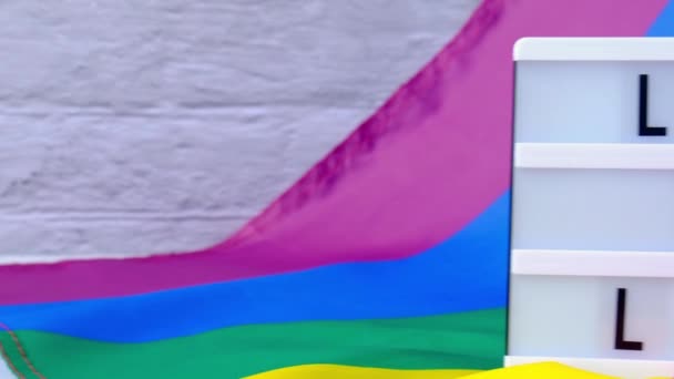 Флаг 4k Rainbow с лайтбоксом и текстом LOVE IS LOVE. Флаг Rainbow lgbtq изготовлен из шелкового материала. Символ месяца гордости ЛГБТК. Равные права. Мир и свобода — стоковое видео