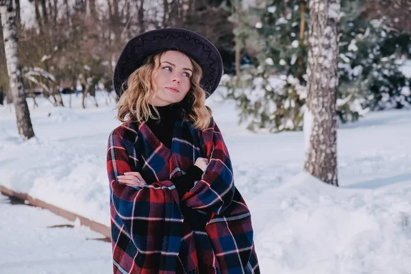 Mujer joven disfrutando del clima invernal en el parque de nieve. Clima frío. Moda de invierno, vacaciones, descanso, concepto de viaje. Sombrero y poncho de vaquero. — Foto de Stock