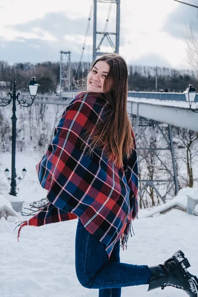 Каштановые длинные волосы симпатичная молодая женщина в пончо в зимнем парке. Холодная. Отдых, сезон и концепция отдыха. Рождество, Новый год. — стоковое фото