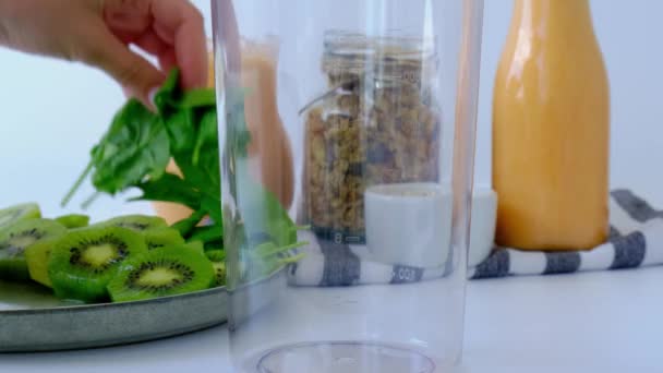 4k妇女烹调健康的冰沙添加青苹果，奇异果菠菜混合在搅拌机绿色冰沙。节食、减肥、减肥和膳食规划概念. — 图库视频影像