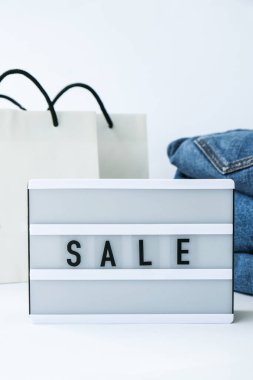 Kağıt alışveriş torbaları, kot giysileri olan kısa pano satışı. İnternetten alışveriş konsepti. Promosyon reklamcılığı. Tatil Siber Pazartesi.