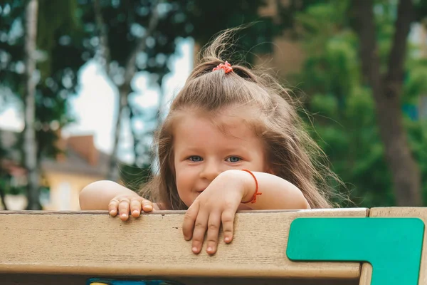 Kind op hindernisbaan. Vrij gelukkig jong meisje dat buiten speelt in de speeltuin. Portret van schattig meisje spelen op speeltuin — Stockfoto