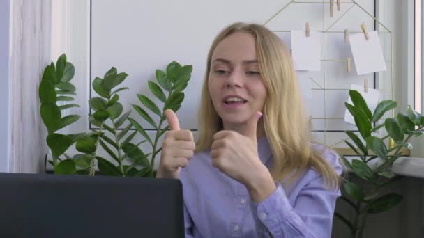 Una joven que trabaja en una computadora en casa. Feliz mujer de negocios sonriente y agradecida trabajando en su portátil. Tutoría en línea de conferencias. Estudiante de educación en línea — Vídeo de stock