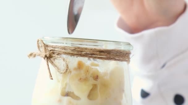 Mains féminines, femme qui mange Petit déjeuner sain. Granola d'avoine 4k avec yaourt grec et muesli de banane aux noix dans un bocal. Vegan, végétarien et concept de régime de perte de poids. Menu désintoxication. — Video