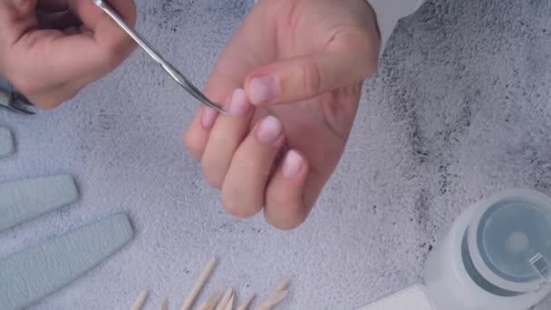 Las manos femeninas hacen manicura. Elimina el cuidado de las uñas cutáneas, el autocuidado. Haz la manicura tú solo mientras te quedas en casa. Diy. Pintura, lima y forma ovalada uñas. — Vídeos de Stock