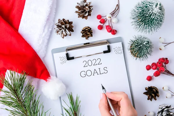 2022 goals paper sheet around christmas new year decorations. Planning year concept. Copy space. Flat lay. Top view. Doubt concept. Time to plan