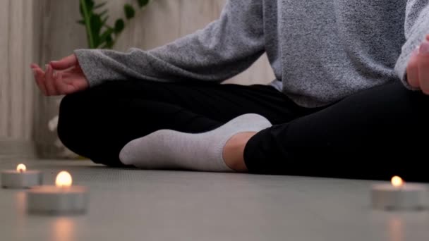 Detailní záběr. Žena doma cvičí jógu. Meditace bdělosti. Relax dýchat snadné póza tělocvična zdravý životní styl koncept. Hořící svíčky. Lotus asana. Atmosféra odpočinku a zenu. — Stock video