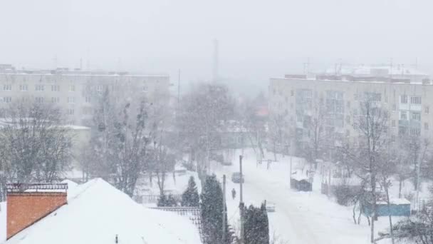 Slow motion of snow falling. Snow-covered city and flying snowflakes in slow motion. Defocused. Selective focus. Blurred winter background cold weather — Stock Video