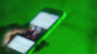 Akıllı telefonlu odaksız kadın elleri sokaktaki son moda neon ışıklara yakın. Yaşam tarzı. Akıllı telefon ya da dijital cihaz kullanarak internet bankacılığı için kolay ödeme. Uygulamayla iletişim, mağazada satılıktır. Sosyal