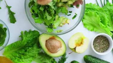 Kadın taze yeşil sebze salatasıyla otları karıştırıyor. Çiğ gıda konsepti. Vejetaryen menüsü. Sağlıklı beslenme ya da vejetaryen yemekleri pişirmek. Adım adım tarif.