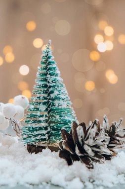 Bokeh Light arka planında Noel ağacı. Yeni yıl için en az pastel renk tasarımı. Kış tatili tebrik kartı. Yeşil karlı Noel ağacı süslemeleri