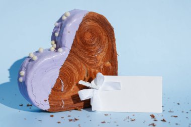 Boş kağıt kart şablonu, mavi arkaplanlı ve fotokopi alanı olan Kalp şeklinde yaban mersini aromalı kruvasan. Puf puf yeni moda tatlı pastanesi. Kremalı hamur deneyi 
