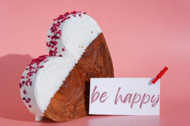 Kağıt üzerinde mutlu sözler olsun. Tebrik kartı. Renkli Ganache aromalı taze kruvasan. Eşsiz kalp şekilli fırın. Puf puf böreği, bayram aşkı hediyesi. Sevgililer Günü fikri.