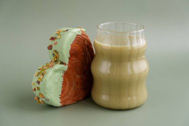 Yeşil çay Matcha latte cappuccino içeceği Sabah kahvaltısı hediye fikri Fotokopi alanlı yeşil arka planda fıstık şeklinde kruvasan. Puf puf yeni moda tatlı pastanesi. Kremalı hamur
