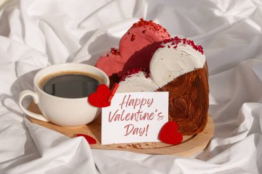 Sevgililer Günü 'nüz kutlu olsun. Kutlama kartında, kırışık yatak döşeğinde kahvaltınız ve kruvasan kekiniz var. Gıda deneyleri viral tatlı yaratıcı pişirme eğilimi