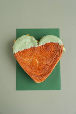 Lezzetli ve canlı kalp şeklinde hamur işi kruvasan. Renkli fındık şekeriyle kaplanmış. Şablon kopyalama alanı oluşturun. Gıda deneyleri viral tatlı yaratıcı pişirme eğilimi