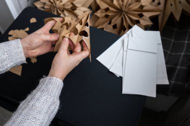 Noel yıldızı ve yeni yıl arifesi için hazırlanma süreci. Üç boyutlu el çantası kar tanelerini boyamış. Sorumlu ekolojik sıfır atık el yapımı dekorasyon. Çocuk hobisi ev dekorasyonu